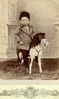 Toy Horse Prints: Portrait of a boy sitting on a toy horse