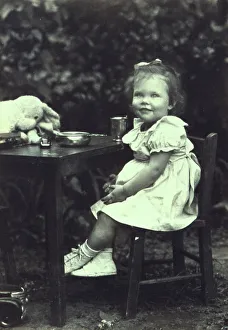Portrait of a young girl seated at an outdoor table, facing front, between 1940 and 1950. Creator: Joseph Woodson Whitesell