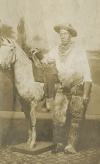 Portraits Prints: Postcard of a man posing in a Western scene in a photography studio, early 20th century