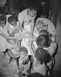 Anniversary Gallery: Pouring lemonade at a birthday party on Seaton Road, Washington, D.C. 1942. Creator: Gordon Parks