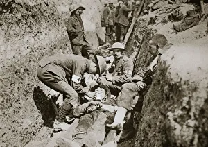 Tending Prints: Red Cross men in the trenches tend a wounded man