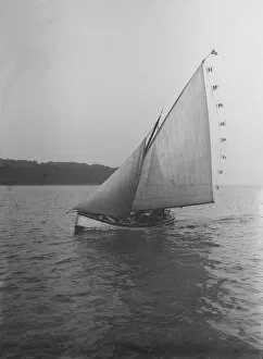 The sailing dinghy Hound with flags, 1912. Creator: Kirk & Sons of Cowes