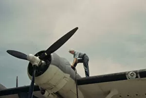 Sailor mechanic fueling a plane at the Naval Air Base, Corpus Christi, Texas, 1942. Creator: Howard Hollem
