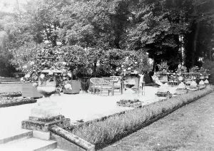 A Shaded gravelled terrace, screened by orange trees, with chaise longues... France, 1925. Creator: Frances Benjamin Johnston