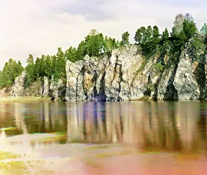 Shaitan Rock; general view from the village of Novaia Derevnia, Chusovaya River, 1912. Creator: Sergey Mikhaylovich Prokudin-Gorsky