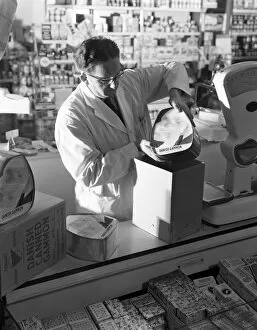 Shopkeeper Gallery: Shopkeeper unpacking canned gammon joints, Mexborough, South Yorkshire, 1963. Artist
