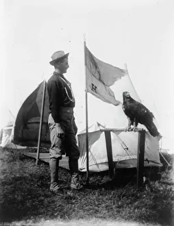 Soldier and eagle mascot beside H Troop flag, 1898. Creator: Frances Benjamin Johnston. Soldier and eagle mascot beside H Troop flag, 1898. Creator: Frances Benjamin Johnston