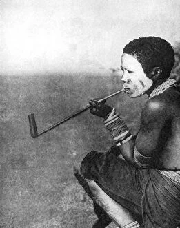 Painted Face Gallery: A South African tribesman smoking, 1936.Artist: South African Railways