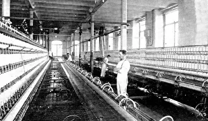 Textile Mill Prints: Spinning the cotton into yarn: a great spinning-mule in use, 1909. Creator: Unknown