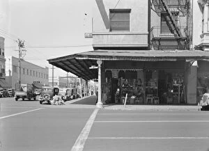 Guitar Gallery: Street corner of San Joaquin Valley town on U.S. 99 showing secondhand store, Fresno, CA, 1939