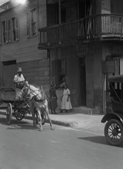 Street scene, including horse- or mule-drawn wagon, New Orleans, between 1920 and 1926. Creator: Arnold Genthe