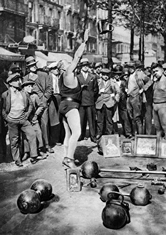 Strongman juggling with weights, Paris, 1931.Artist: Ernest Flammarion Strongman juggling with weights, Paris, 1931.Artist: Ernest Flammarion