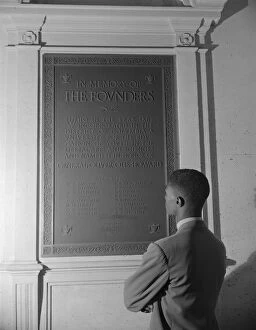 Student reading bronze plaque in library of Howard University, Washington, D.C. 1942. Creator: Gordon Parks