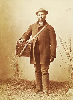 Studio portrait of man holding box labelled Confectionery, c1880. Creator: William Notman