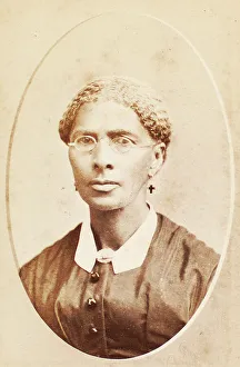 Studio portrait of woman wearing glasses and cross-shaped earrings, c1880-c1889. Creator: George Daniels Morse
