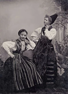 Leaning On Elbow Collection: Studio portrait of two young girls posing in folk costumes from Dalarna, 1880-1907