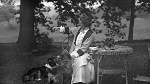 Arm Out Prints: Tarbell, Ida, Miss, with dogs, seated outdoors, 1912 or 1913. Creator: Arnold Genthe