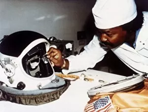 Artificer Gallery: Technician installing eye-glasses in helmet. Creator: NASA