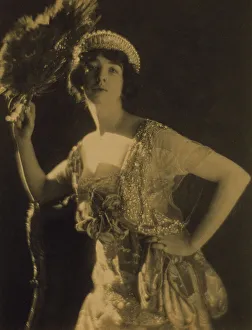 Three-quarter length portrait of Gertrude Vanderbilt Whitney...holding a peacock feather fan, c1916. Creator: Adolph de Meyer