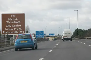 Traffic on M27 Motorway with brown tourist information sign