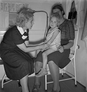 Illness Gallery: In trailer clinic, the nurse consults the migrant... Merrill FSA camp, Klamath County, Oregon