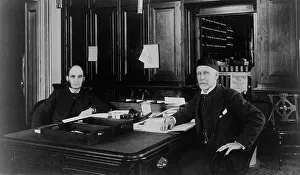 Bureaucracy Prints: Two Treasury Department employees seated at desk in office
