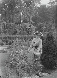 Truesdale, W. Mrs. standing in a garden, 1915 July 6. Creator: Arnold Genthe