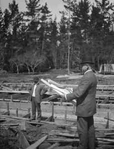 Unidentified man at a construction site studying building plans, between 1896 and 1942. Creator: Arnold Genthe