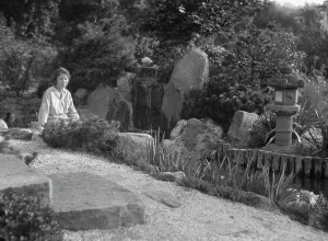 Unidentified woman seated in a garden next to a stream, possibly belonging to A.W. Bahr, c 1917-1934 Creator: Arnold Genthe