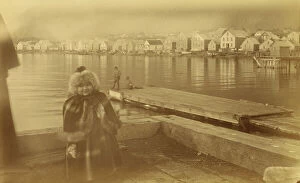 Figures Collection: Unidentified young girl standing on wharf, with buildings along waterfront...,1894 or 1895