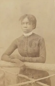 Unidentified young woman wearing gloves, leaning on prop fence, c1880. Creator: H. A. Insley
