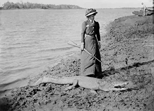 1910 Prints: Unknown lady with rifle and a saltwater crocodile