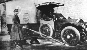 War Work Gallery: Volunteer English woman driver washing down her ambulance, Cambridge, World War I, 1915