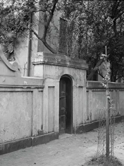 Wall with gate enclosing a building, New Orleans or Charleston, South Carolina, c1920-1926. Creator: Arnold Genthe