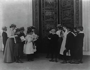 Washington, D.C. school children on field trip - examining the bronze Columbus door... (1899?). Creator: Frances Benjamin Johnston. Washington, D.C. school children on field trip - examining the bronze Columbus door... (1899?)