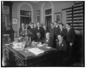 William Jennings Bryan with group at desk, between 1910 and 1920. Creator: Harris & Ewing. William Jennings Bryan with group at desk, between 1910 and 1920. Creator: Harris & Ewing
