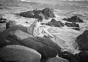 Wilson, Helen, Mrs. seated on rocks at the beach, between 1906 and 1928. Creator: Arnold Genthe