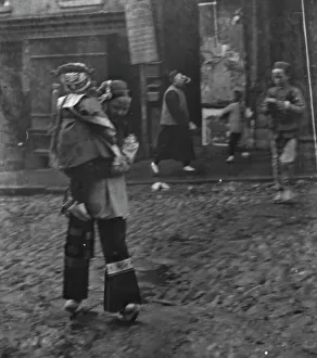 Chinese Americans Prints: Woman carrying a child crossing a street