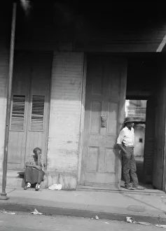 Shutters Prints: Woman sitting on steps and man standing in a doorway
