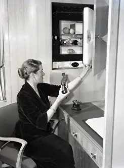 Desk Prints: Woman using a compact fridge, possibly on board a ship