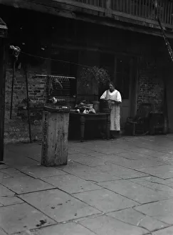 Birdcage Prints: Woman working in a courtyard, New Orleans, between 1920 and 1926. Creator: Arnold Genthe