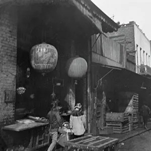 Californian Prints: Two women and a child walking down a sidewalk betwen crates