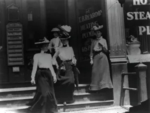 Shop Assistant Prints: Women coming from work, Cal.?. Store window reads T