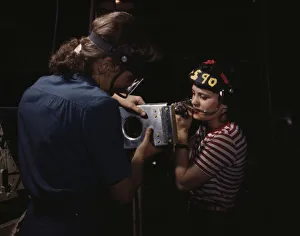 Assembly Line Methods Collection: Two women employees of North American Aviation, Incorporated, assembling a section of a... 1942