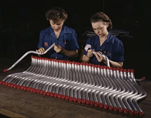 Employee Gallery: Two women workers are shown capping and inspecting tubing...Vultees Nashville... Tennessee, 1943