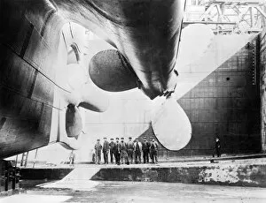 Belfast Gallery: Workmen standing under one of the propellors of the Titanic, 31 May, 1911 (b / w photo)