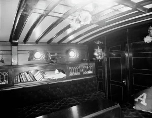 Porthole Prints: Yacht Althea, cabin, showing books, between 1907 and 1915. Creator: Unknown
