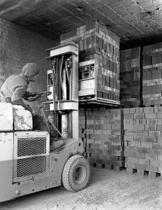 Leicestershire Prints: A yardsman stacking pallets of bricks