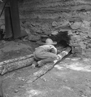 Child Labour Gallery: Ten year old son of tobacco tenant tends the fire... Granville County, North Carolina, 1939