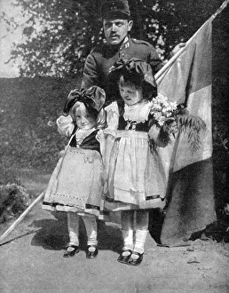 Young Alsatian children in traditional dress with a French soldier, World War I, 1915